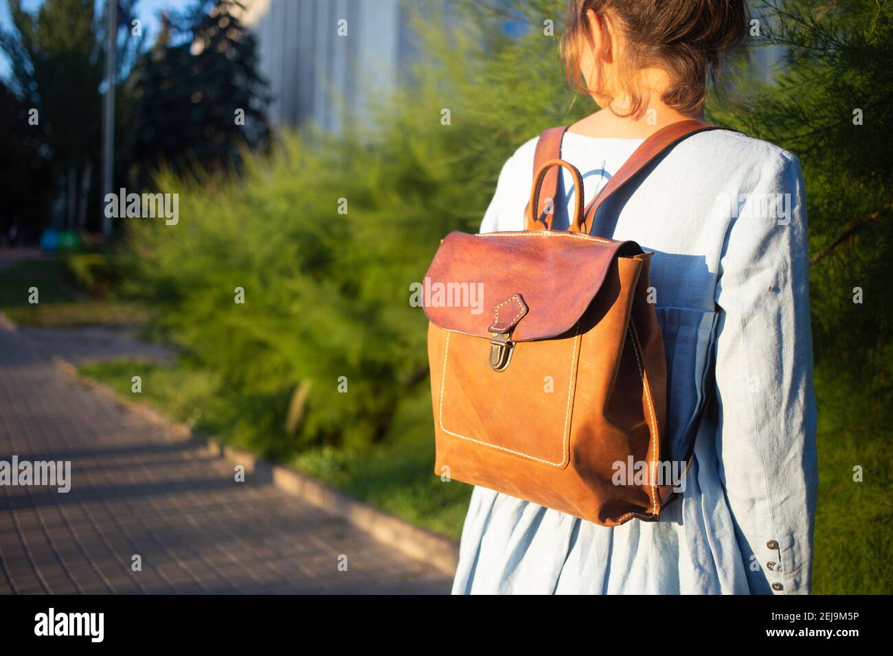 Ragazza indossare pelle moda borsa fatta a mano. Zaino in pelle prodotto artigianale. Foto Stock