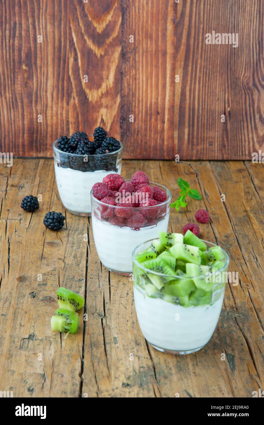 tre bicchieri di yogurt con pezzi di frutta Foto Stock