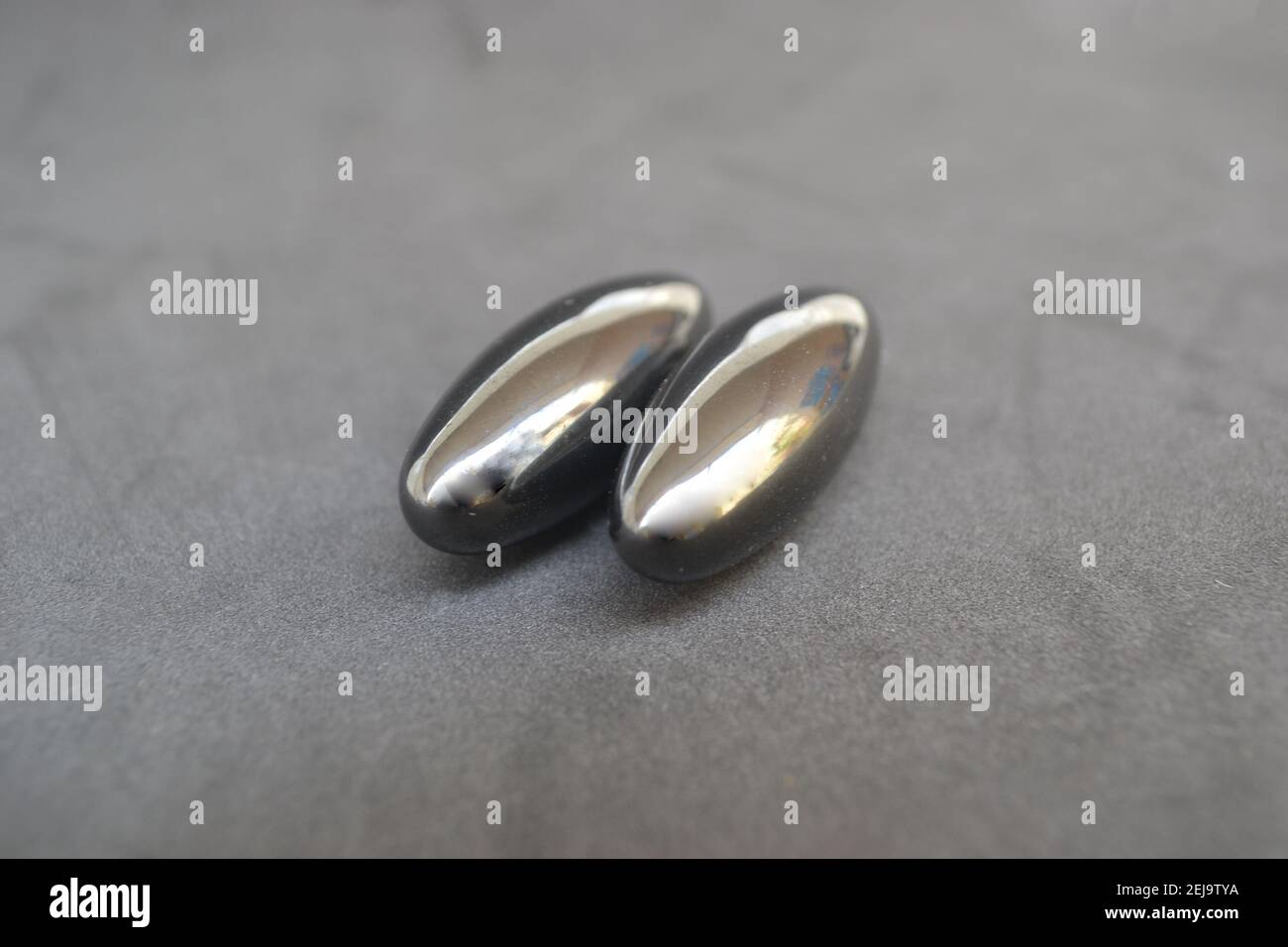 Magnete, due unità di magnete nero o ima o magnete su sfondo bianco incollate insieme nello spazio di copia in zoom Foto Stock