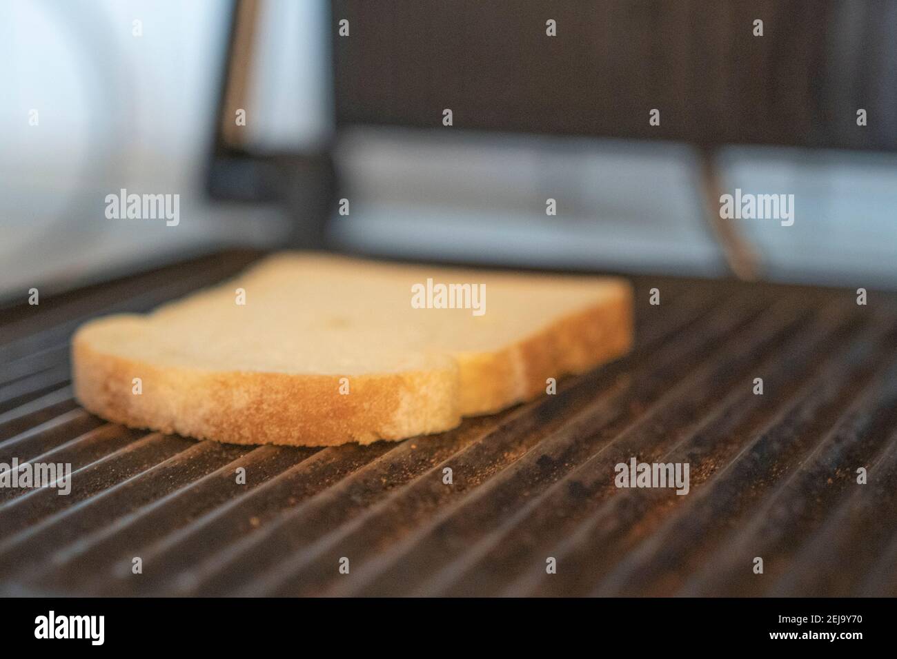 Fetta di pane che tostano su un grill Foto Stock