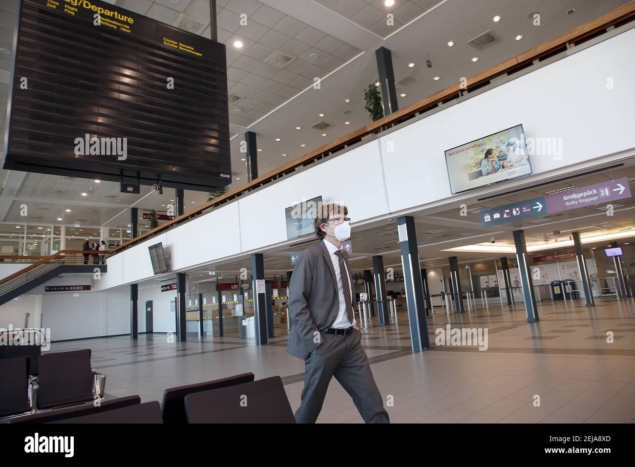 Berlino, Germania. 22 Feb 2021. Engelbert Lütke Daldrup, capo dell'aeroporto, cammina attraverso la sala di check-in deserta e supera la bacheca estinta su quello che è provvisoriamente l'ultimo giorno di operazioni al Terminal 5 dell'aeroporto della capitale BER. A seguito della crisi dei numeri dei passeggeri, il vecchio terminale sarà inizialmente portato fuori linea per un anno per motivi di costo. Le operazioni di BER saranno quindi eseguite esclusivamente attraverso il nuovo terminal 1. Foto: Wolfgang Kumm/dpa Credit: dpa Picture Alliance/Alamy Live News Foto Stock