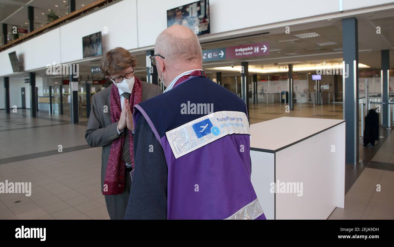 Berlino, Germania. 22 Feb 2021. Engelbert Lütke Daldrup, amministratore delegato dell'aeroporto, si trova nella sala check-in deserta l'ultimo giorno di funzionamento del Terminal 5 dell'aeroporto della capitale BER e parla con un cappellano aeroportuale. A seguito del crollo dei numeri dei passeggeri, il vecchio terminal sarà tolto dalla rete per un anno per motivi di costo. Le operazioni di BER saranno quindi eseguite esclusivamente attraverso il nuovo terminal 1. Foto: Wolfgang Kumm/dpa Credit: dpa Picture Alliance/Alamy Live News Foto Stock