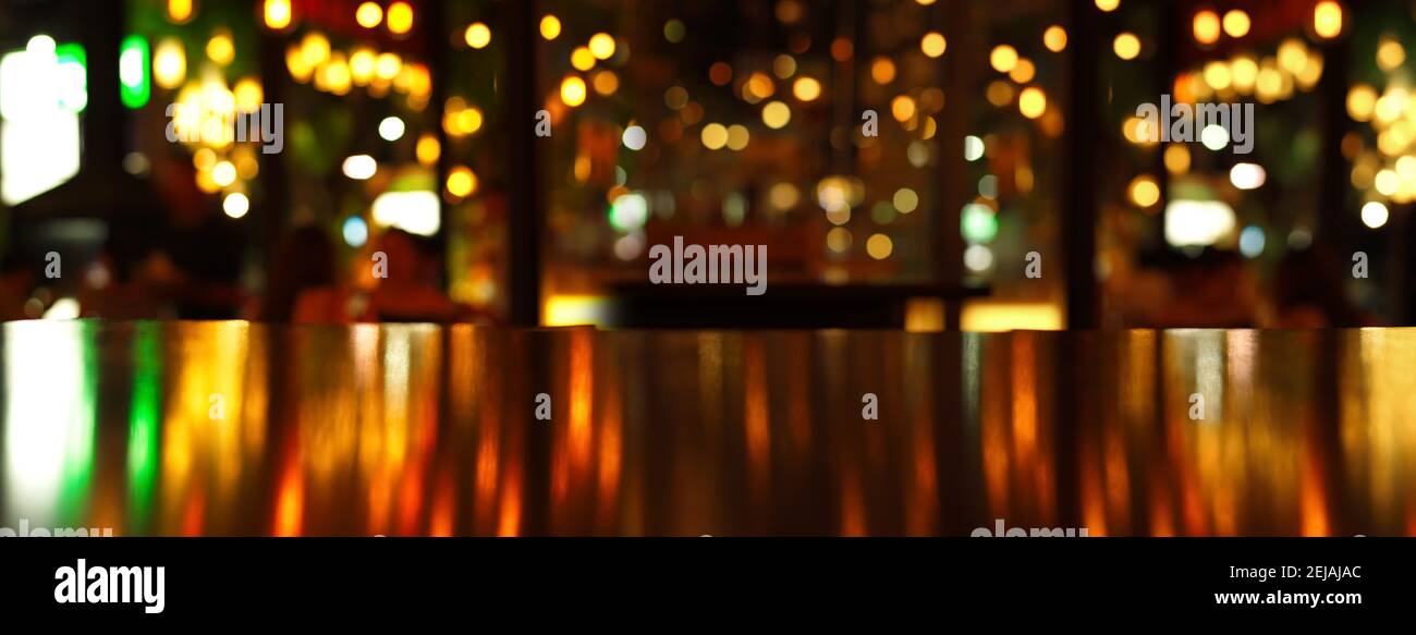 riflesso luminoso della luce della festa sul tavolo di legno nel pub O bar in sfondo banner notte di Natale Foto Stock