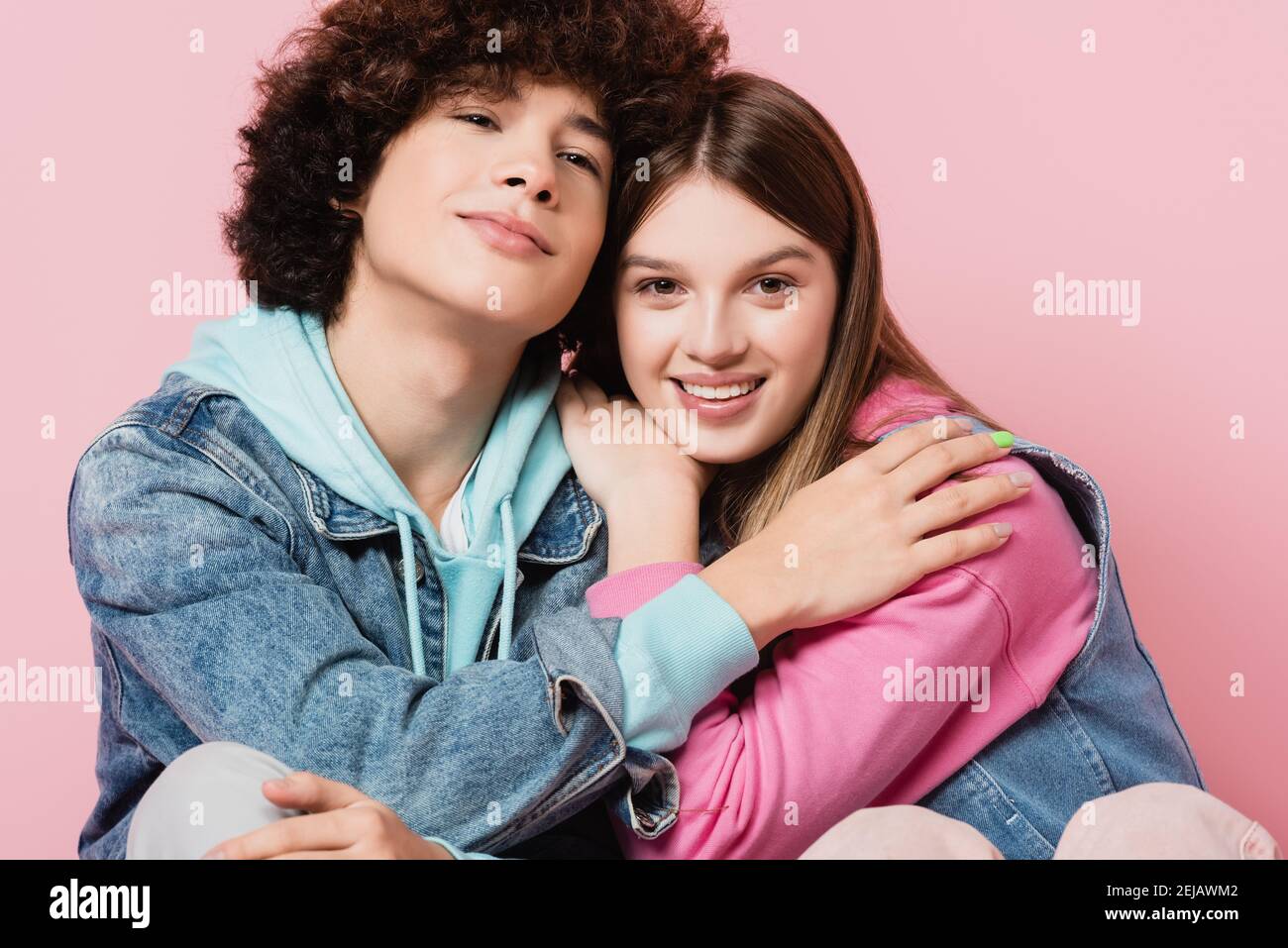 Ragazzi sorridenti che abbracciano isolato su rosa Foto Stock