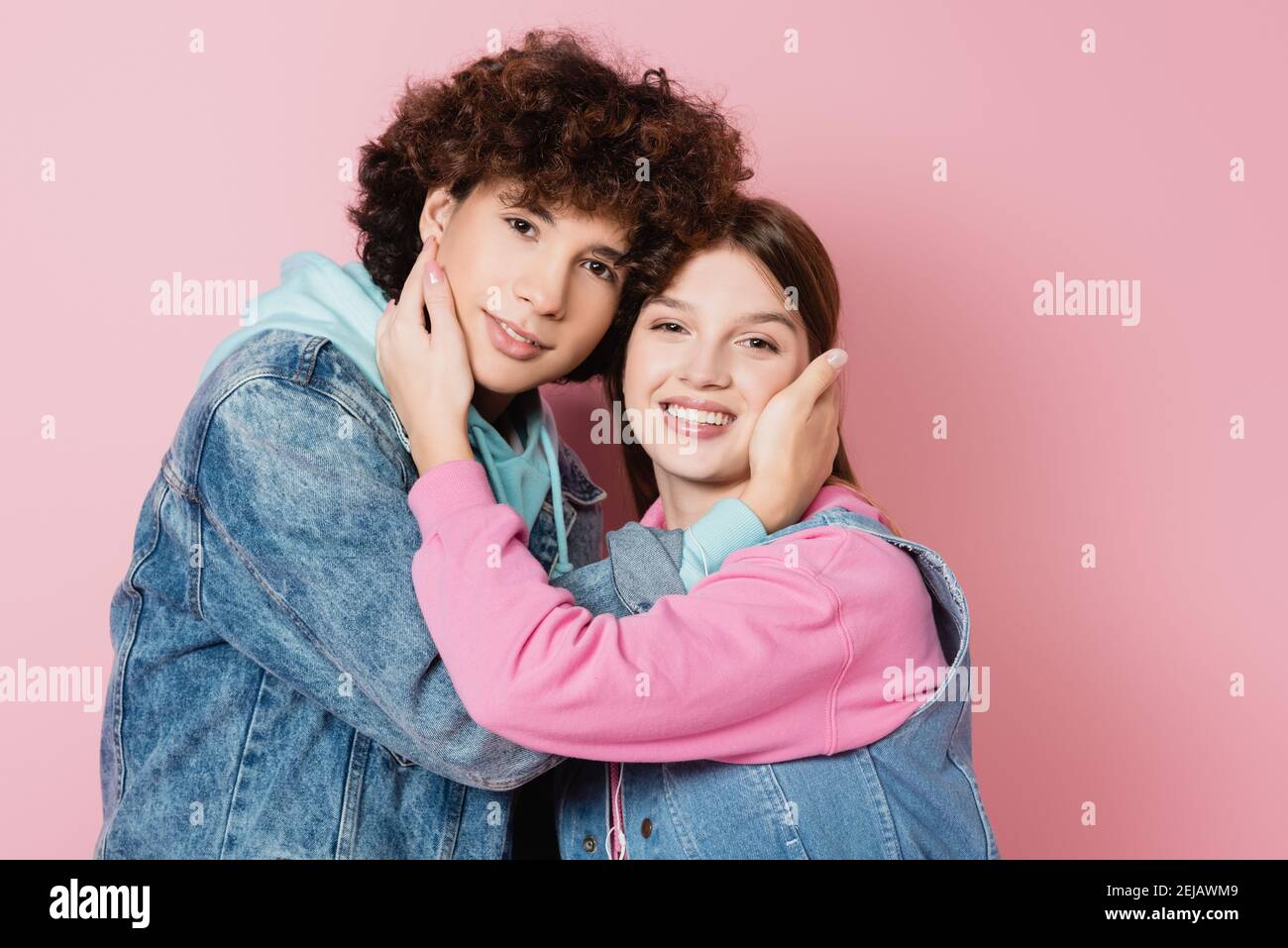 Felice coppia teen abbracciando su sfondo rosa Foto Stock