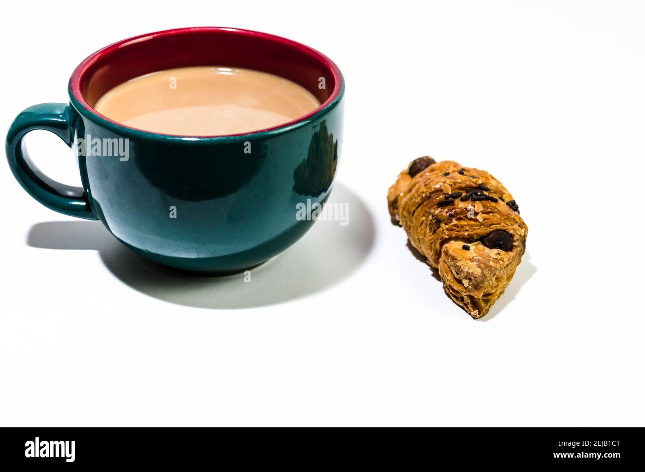 Tazza di caffè latte verde e croissant sul tavolo. Colazione Foto Stock