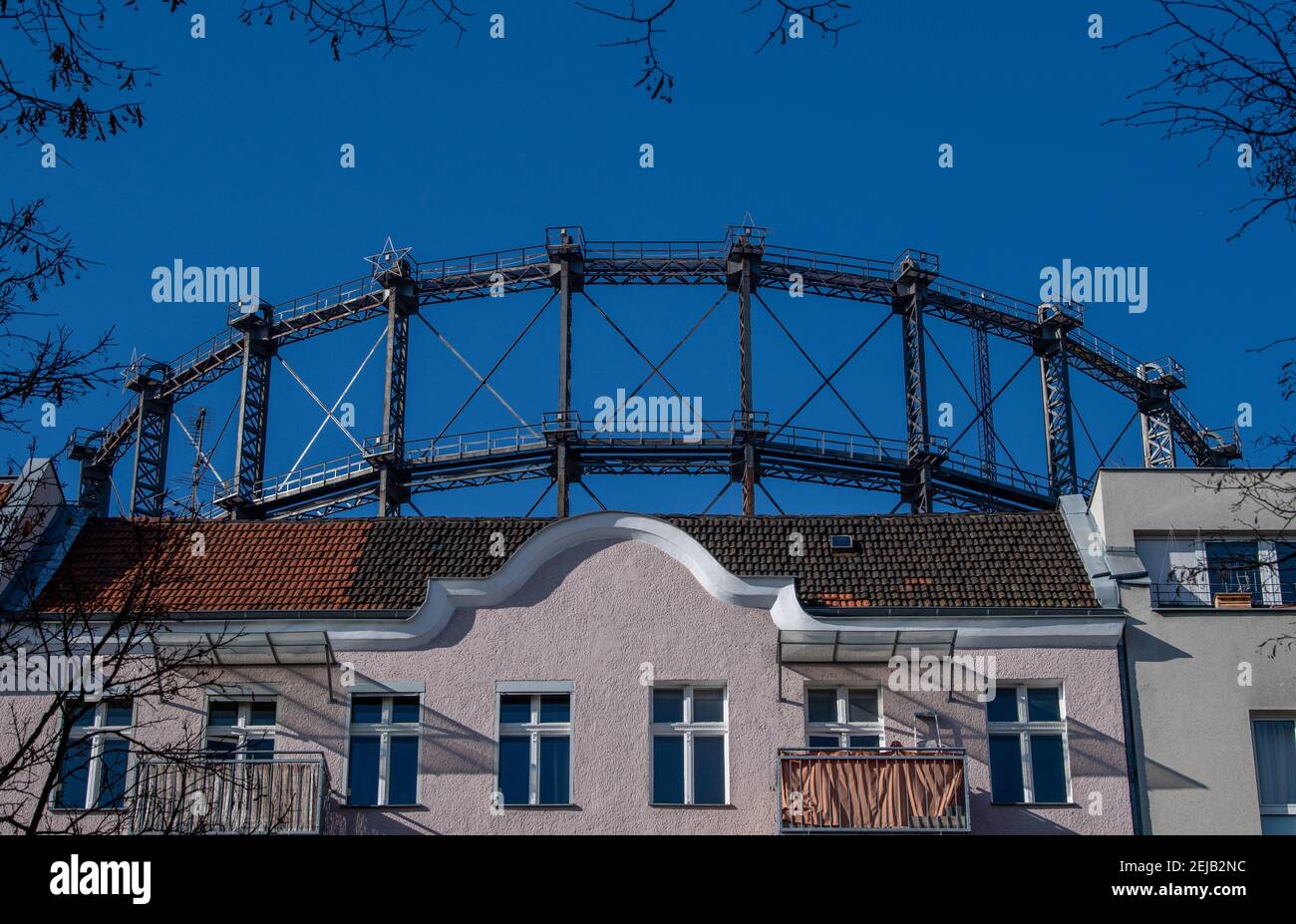 Berlino, Germania. 22 Feb 2021. Il gasometro di Schöneberg si può vedere dietro una fila di case. La procedura di partecipazione per la conversione del Gasometro in elenco termina il 24 febbraio. Se il proprietario ha il suo senso, la costruzione di acciaio di oltre 100-anno-vecchio deve essere data una nuova locazione di vita come il guscio di un edificio di ufficio. Tuttavia, un'iniziativa dei cittadini vuole evitare questo fenomeno e chiede la firma di una petizione. Credit: Paul Zinken/dpa-Zentralbild/dpa/Alamy Live News Foto Stock