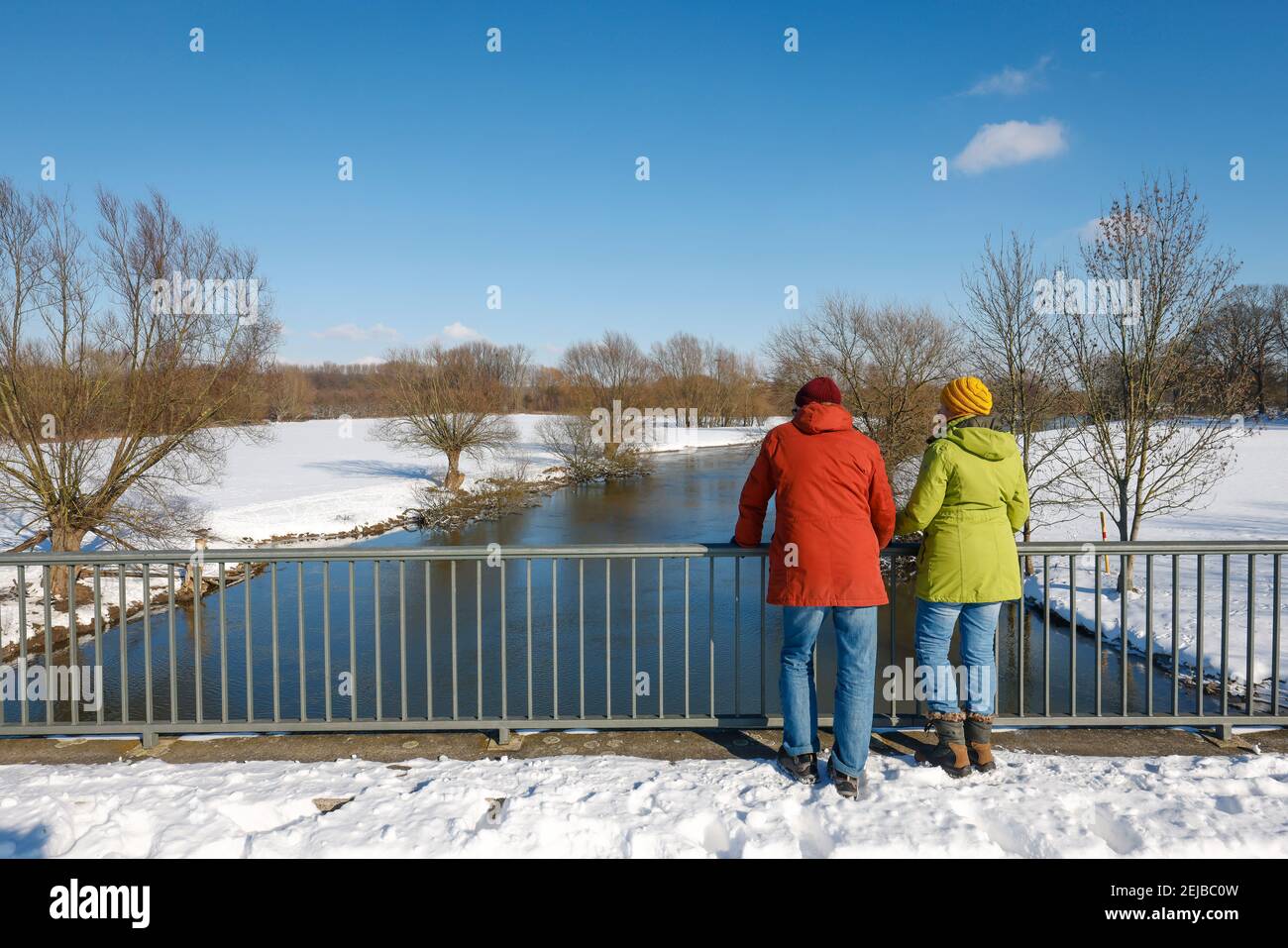 Hamm, Nord Reno-Westfalia, Germania - Sunny paesaggio invernale nella zona della Ruhr, ghiaccio e neve sul fiume Lippe, escursionisti in piedi su un ponte. Foto Stock