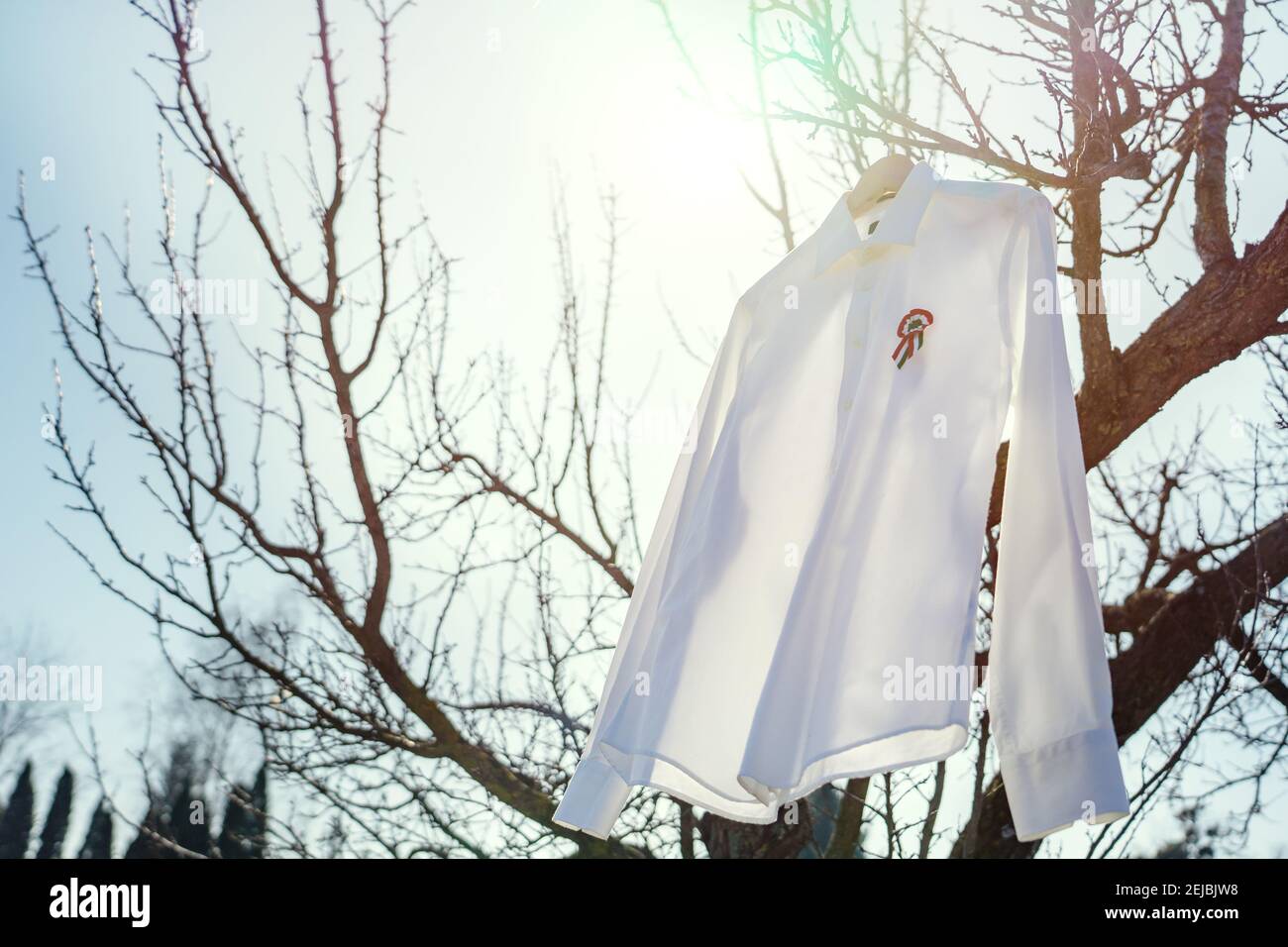 camicia bianca appesa all'esterno con rosetta tricolore simbolo del giorno nazionale ungherese 15 marzo . Foto Stock