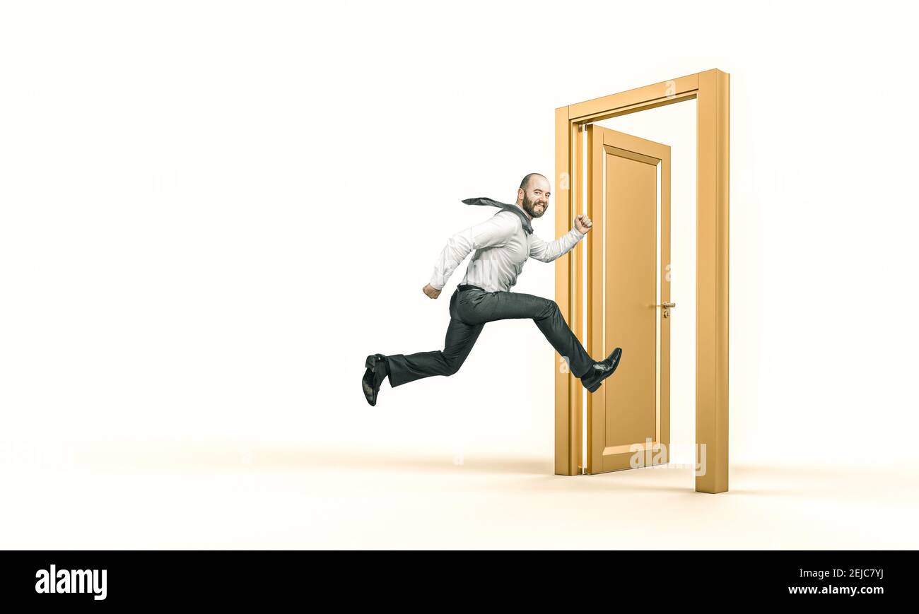 un uomo d'affari sorridente corre ed entra in una porta d'oro. concetto di successo. Foto Stock