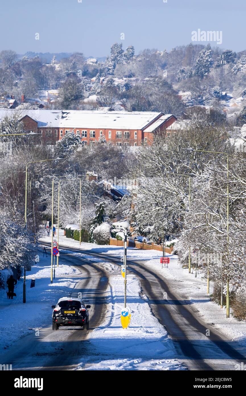 Guida in auto su una strada innevata in una giornata invernale a Market Harborough, Leicestershire, Regno Unito. Foto Stock