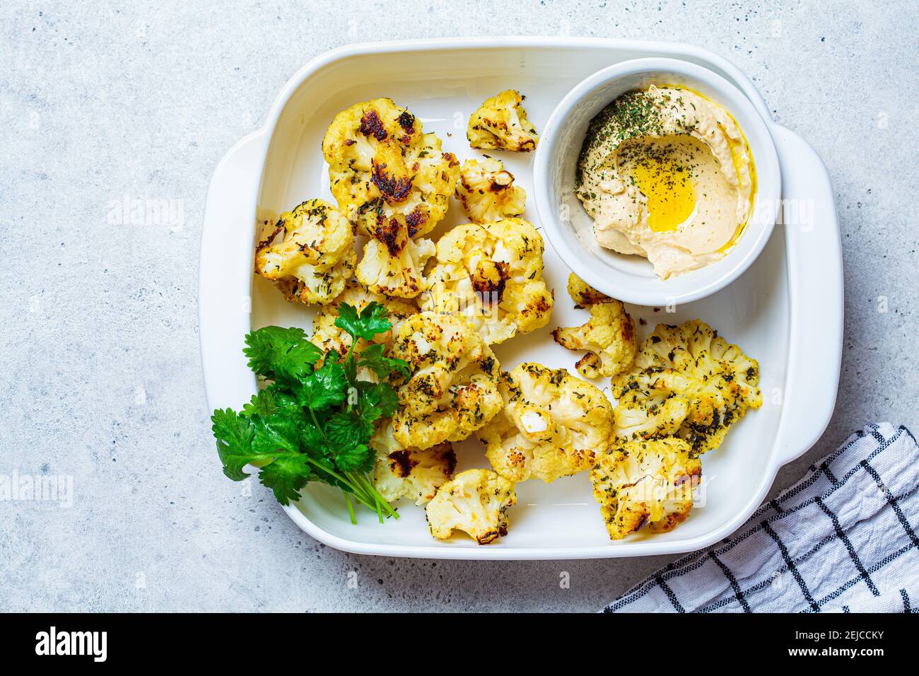 Cavolfiore cotto in un piatto bianco con hummus. Concetto di cibo sano. Foto Stock