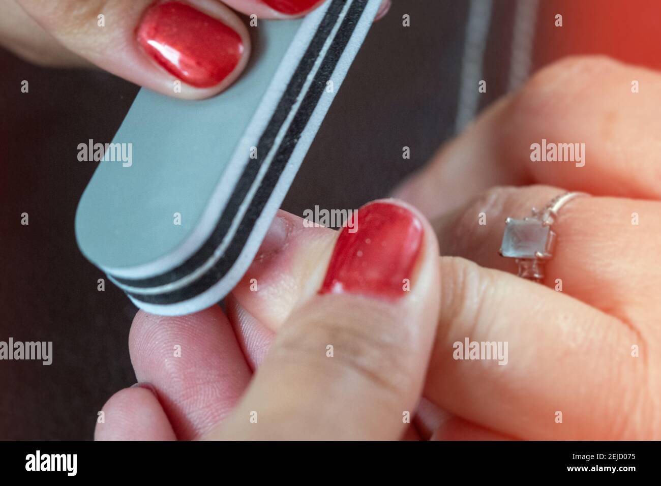 Primo piano di un lavoro di smalto per unghie con le mani delle donne Foto Stock Primo piano di un lavoro di smalto per unghie con le mani delle donne Foto Stock