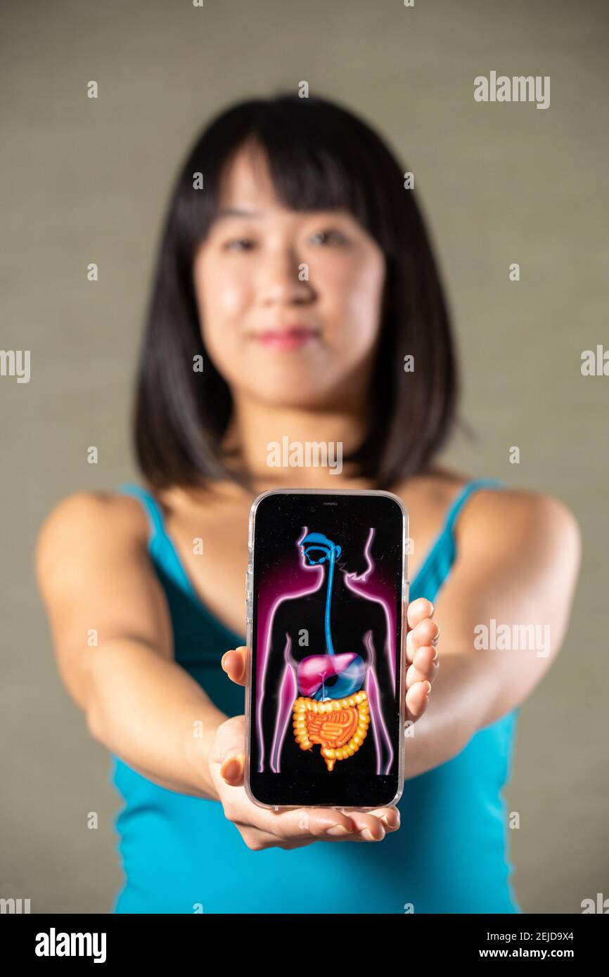 Donna che tiene schermo con disegno di sistema digestivo Foto Stock
