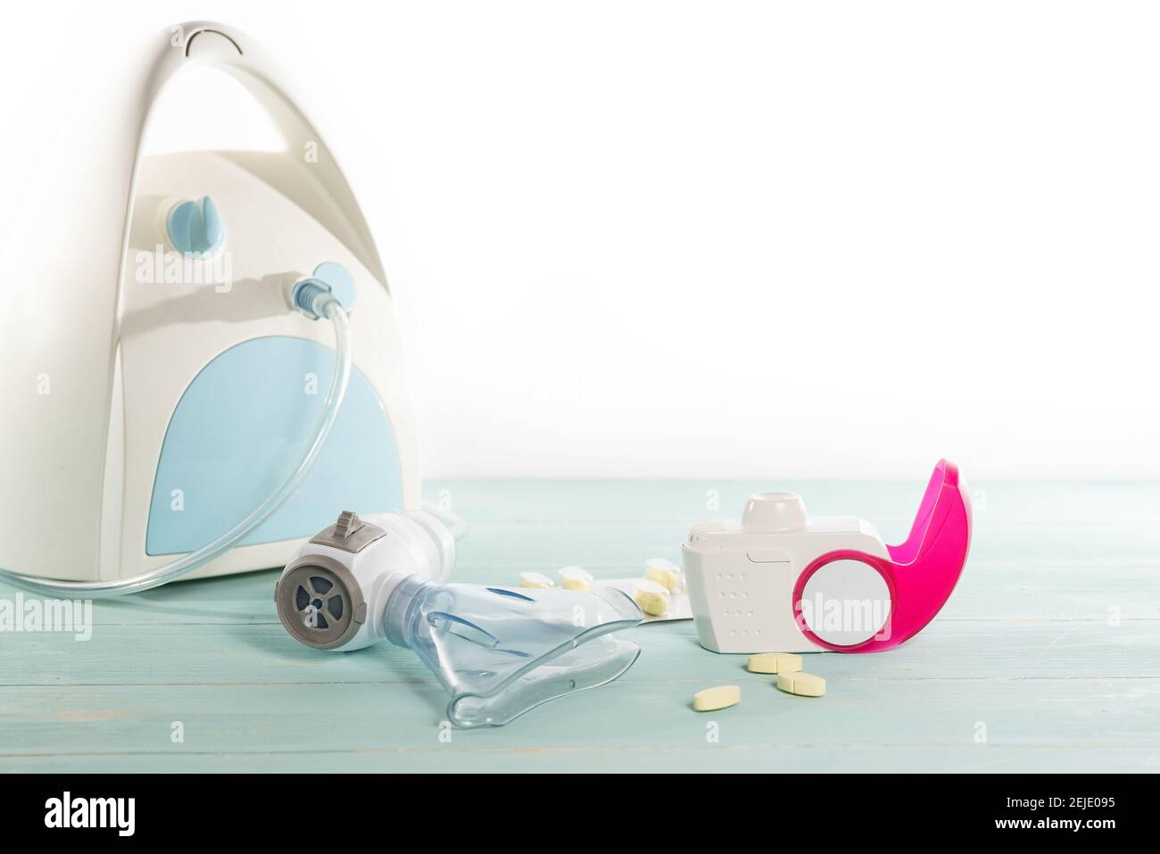 Set di inalatore per asma, pillole antiallergiche e aerosol con maschera inalatore, concetto di asma e trattamento su sfondo verde, spazio copia. Foto Stock