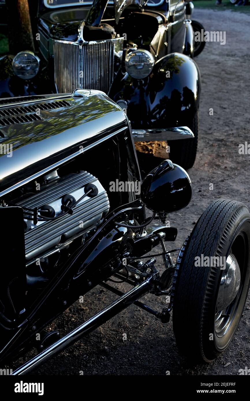 Auto classiche lucenti nere parcheggiate presso l'Hotrod Hayride, durante il tramonto, Heathfield, Regno Unito. Foto Stock