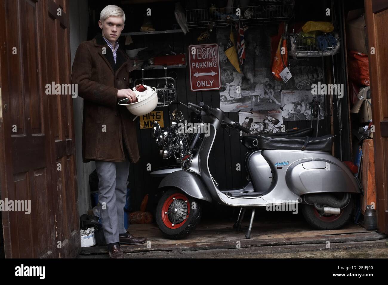 GRAN BRETAGNA / Inghilterra / giovane mod su lambretta scooter posing in garage Foto Stock