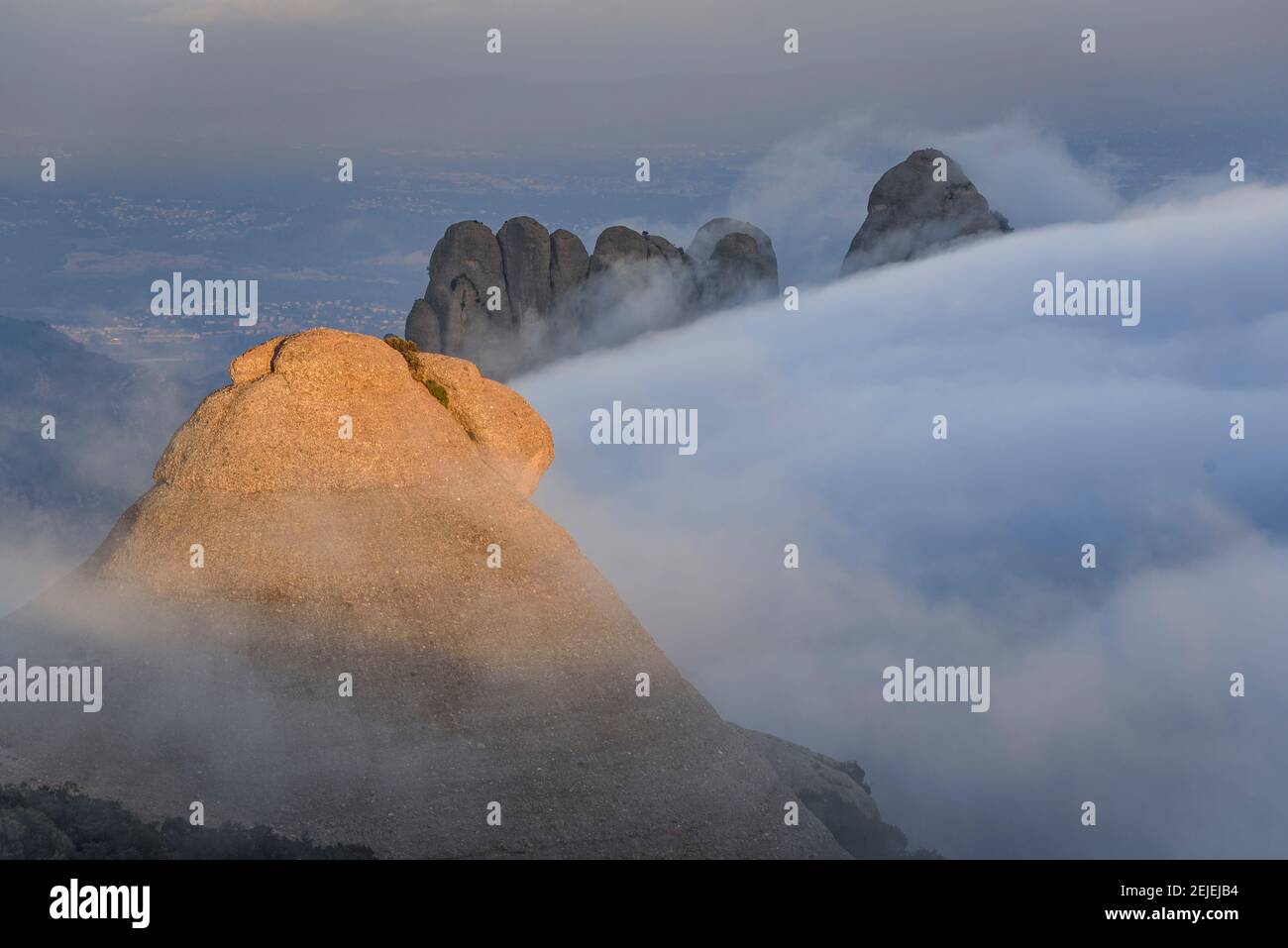 Tramonto a Montserrat con nebbia che guarda alle guglie di El Moro e Els Flautats, visto dalla cima di Sant Jeroni (regione di Barcellona, Catalogna, Spagna) Foto Stock