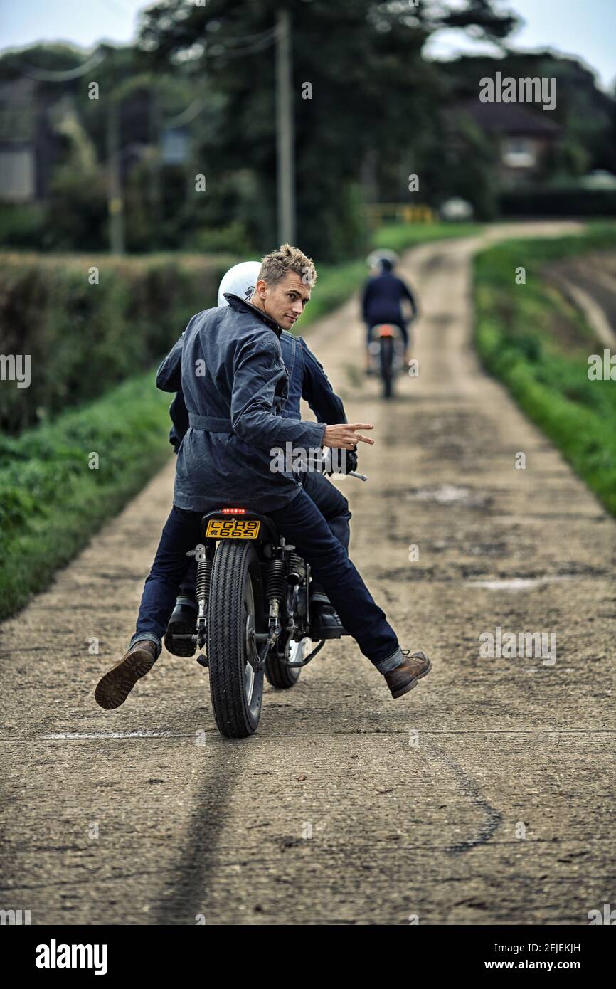 vista posteriore di due motociclisti che guidano su strada con le mani sollevate, il tuo gesto Foto Stock