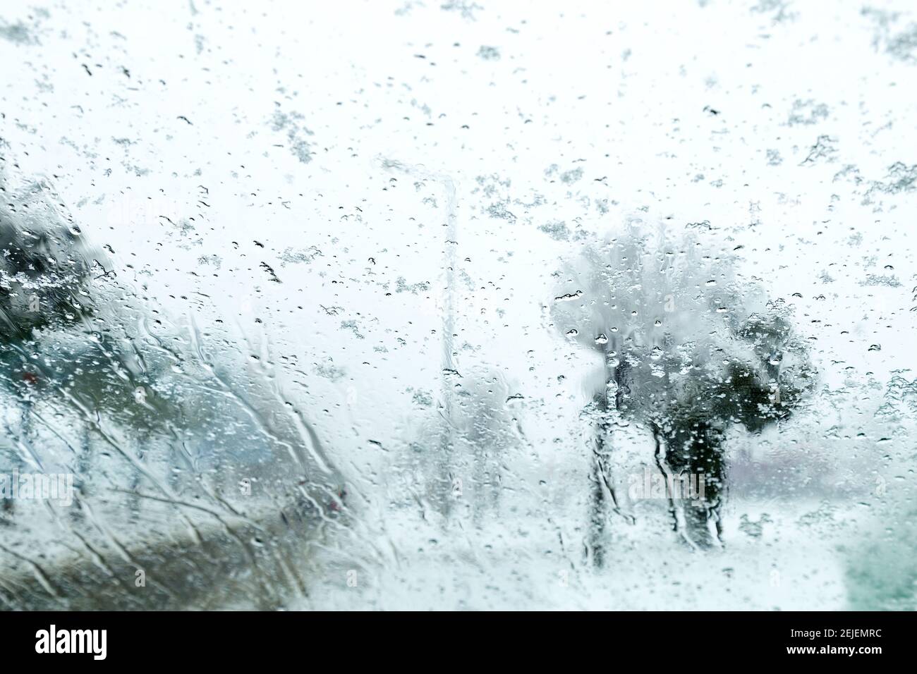 Vista dal finestrino della vettura sulla pista innevata. Vista della strada attraverso il finestrino dell'auto durante la nevicata. Messa a fuoco selettiva. Foto Stock