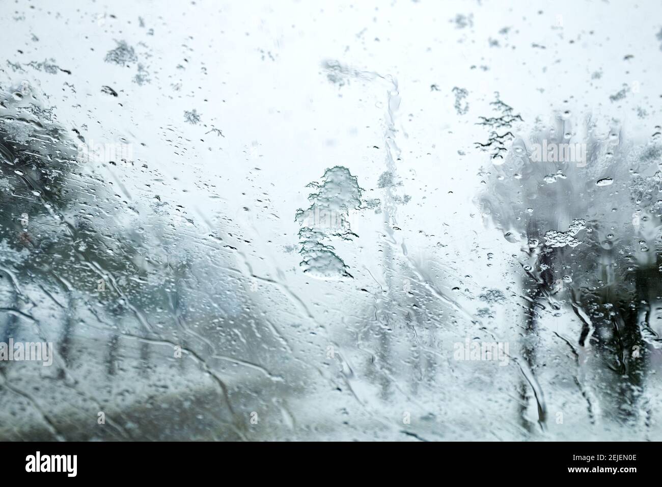 Vista dal finestrino della vettura sulla pista innevata. Vista della strada attraverso il finestrino dell'auto durante la nevicata. Messa a fuoco selettiva. Foto Stock