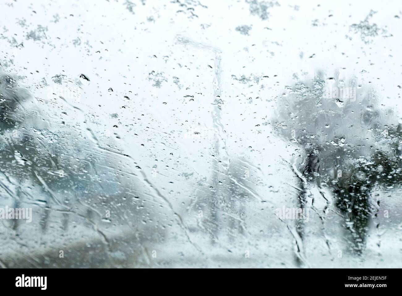 Vista dal finestrino della vettura sulla pista innevata. Vista della strada attraverso il finestrino dell'auto durante la nevicata. Messa a fuoco selettiva. Foto Stock