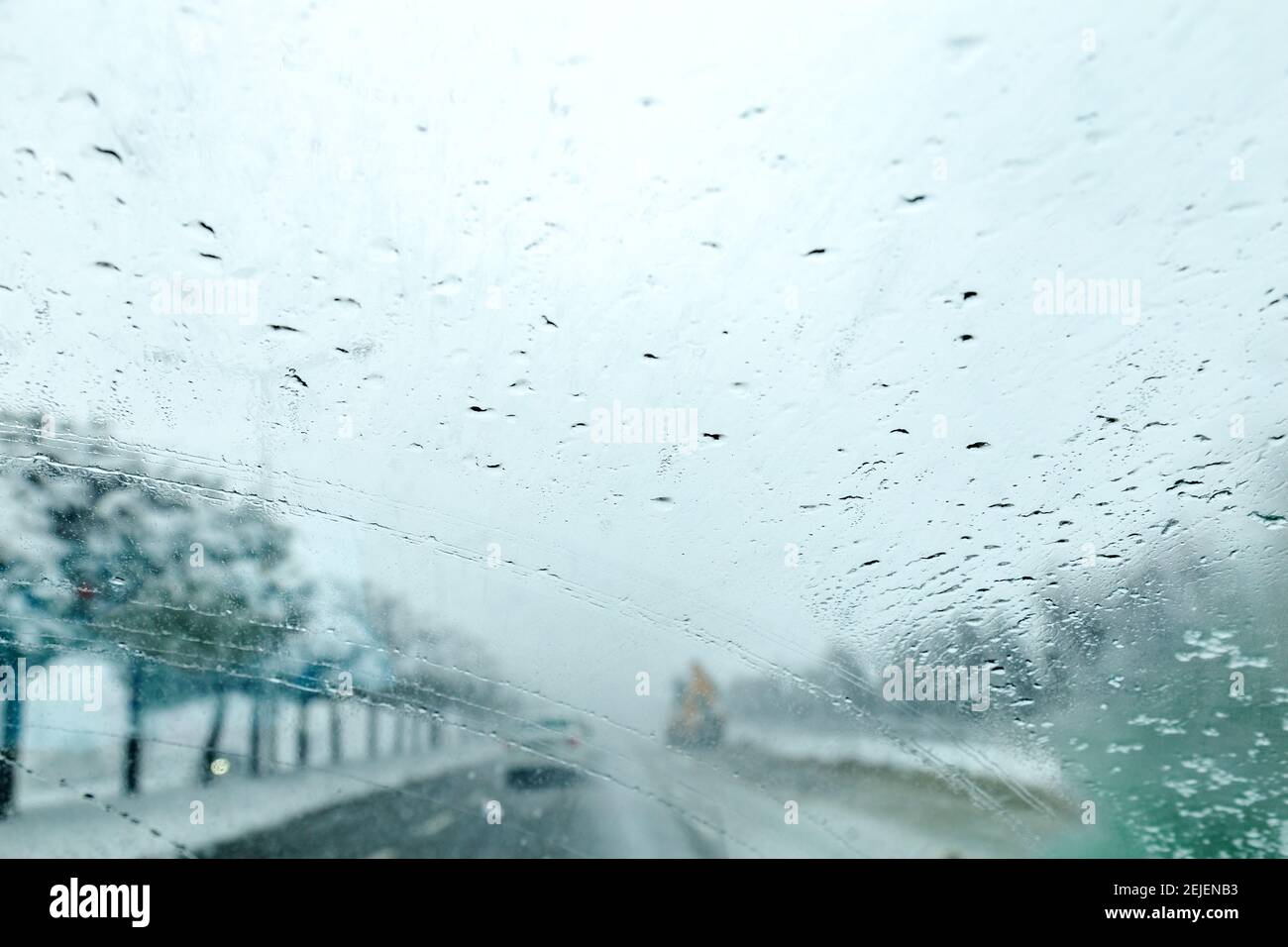 Vista dal finestrino della vettura sulla pista innevata. Vista della strada attraverso il finestrino dell'auto durante la nevicata. Messa a fuoco selettiva. Foto Stock