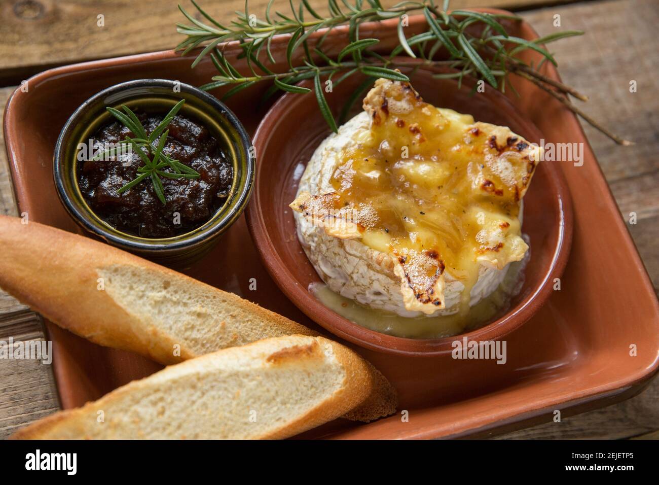 Camembert francese che è stato cotto in forno con tartufo, aglio e salsa al  miele, servito con pane francese tostato e chutney di cipolla caramellata  Foto stock - Alamy