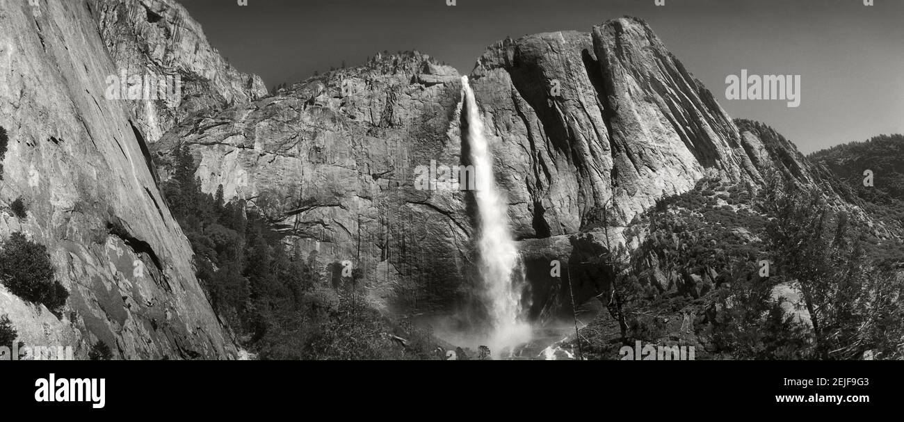 Acqua che cade da rocce in una foresta, Bridalveil Fall, Yosemite Valley, Yosemite National Park, California, Stati Uniti Foto Stock