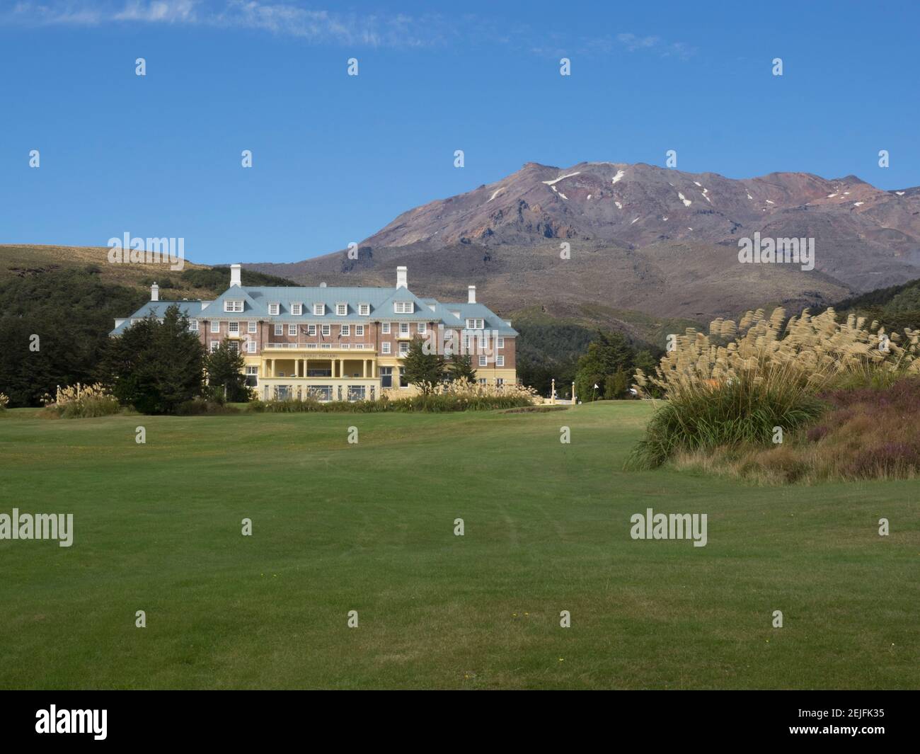 Hotel con catena montuosa sullo sfondo, Chateau Tongariro, Parco Nazionale di Tongariro, Ruapehu, Isola del Nord, Nuova Zelanda Foto Stock