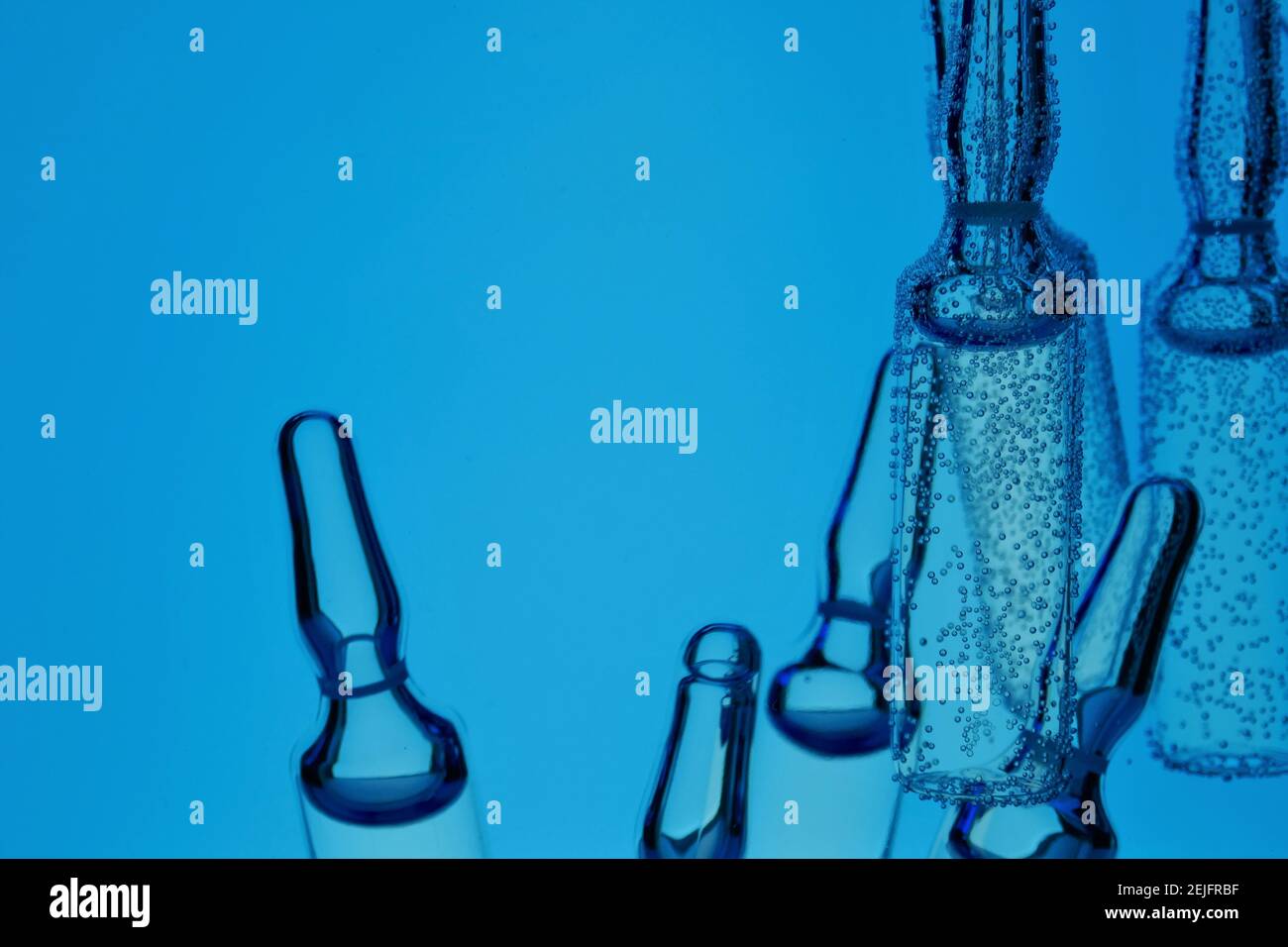 Fiale mediche.vaccino e siero.acido ialuronico.Medicina e bellezza .fiale trasparenti In bolle d'aria in blu Water.Skin idratazione e bellezza Foto Stock