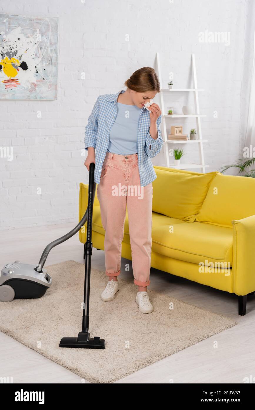 Donna con allergia sulla moquette per la pulizia della polvere con  aspirapolvere Foto stock - Alamy