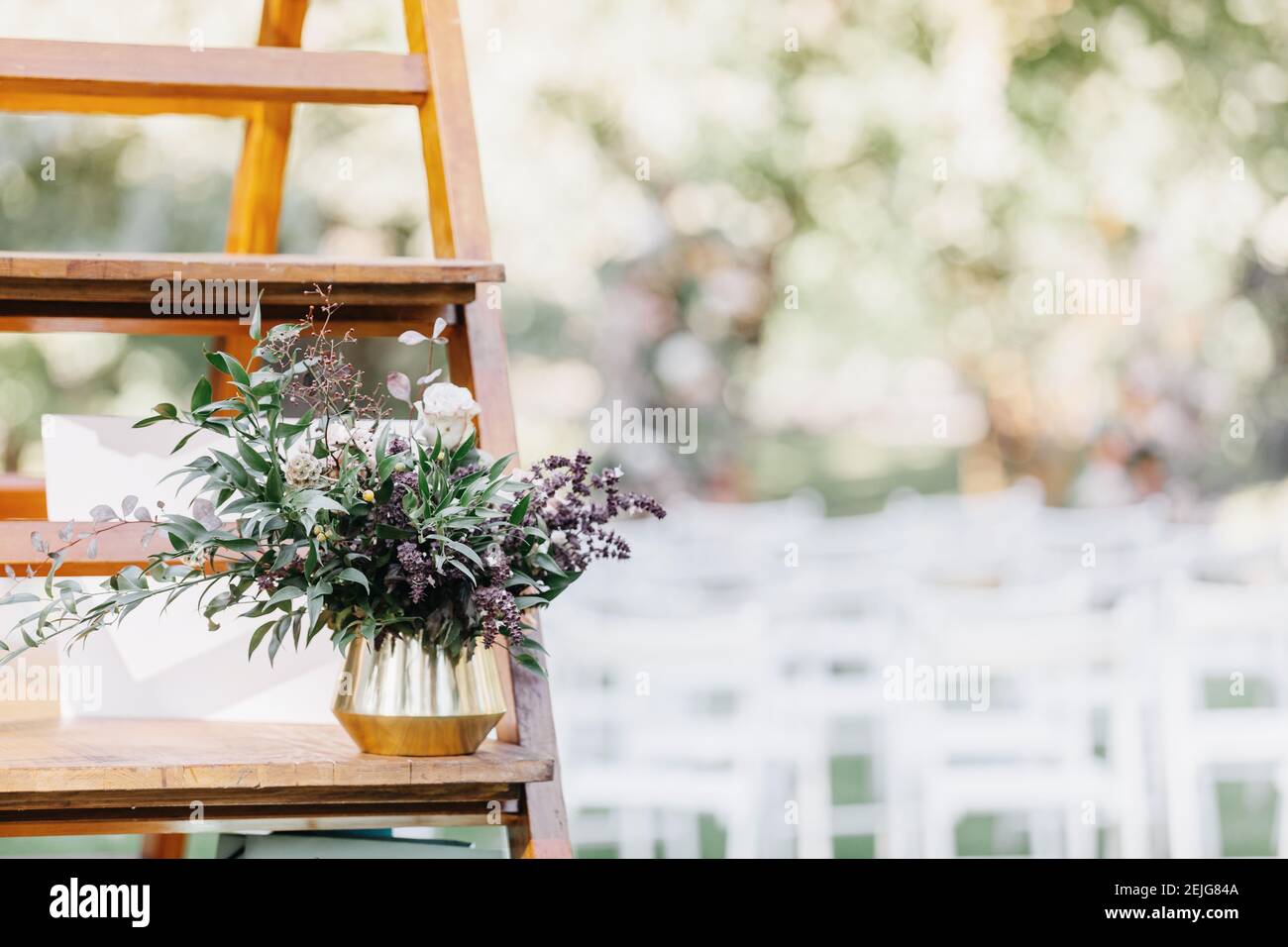 Bouquet moderno in vaso su ripiano in legno per matrimoni all'aperto cerimonia sul prato verde in estate Foto Stock