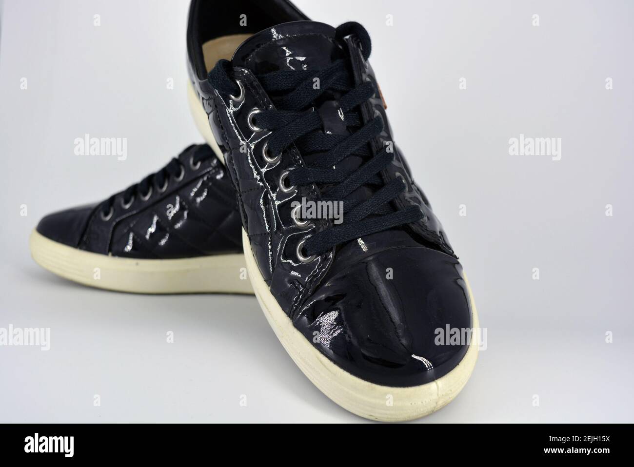 Eleganti scarpe laccate nere lucide su sfondo bianco. Mocassini in vera  pelle con tulshit e lacci larghi neri. Sneake da donna Foto stock - Alamy
