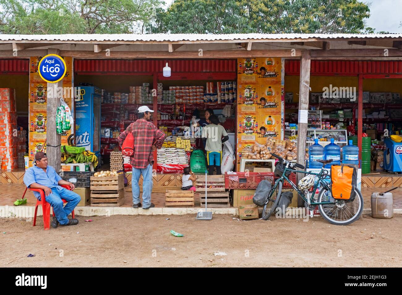 Ciclista itinerante che acquista cibo al negozio di alimentari/negozio di strada in Amazzonia, provincia di Cercado, Dipartimento Beni, Bolivia Foto Stock