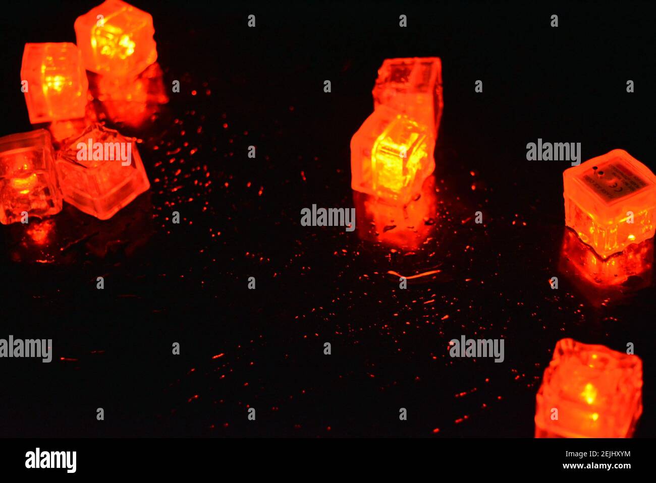 Molto luminoso e non normale sfondo di cubetti di ghiaccio rossi brillanti. Splendida illuminazione dalle mille sfaccettature con una luce speciale. Foto Stock