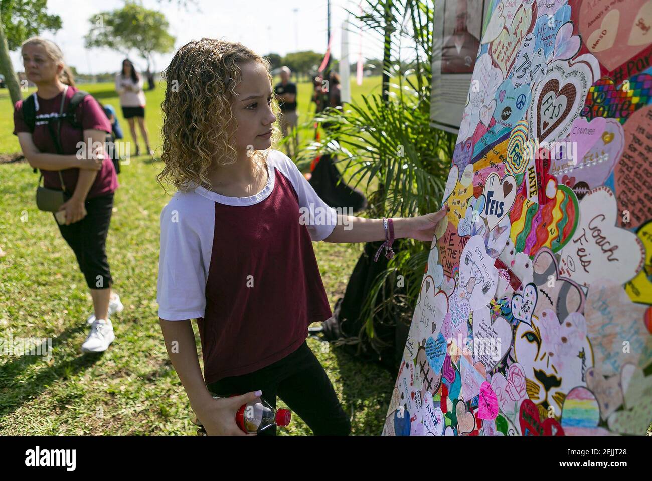 Maci Norkunas guarda un collage d'arte in onore delle 17 vittime uccise al tiro della Marjory Stoneman Douglas High School. L'opera d'arte è stata in mostra al Pine Trails Park durante il biennale delle riprese a Parkland, Fla., venerdì 14 febbraio 2020. (Matias J. Ocner/Miami Herald/TNS) Foto Stock