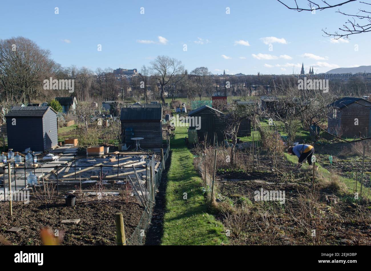 Giardino nel centro della città con vista sul Castello di Edimburgo e donna scavando Foto Stock