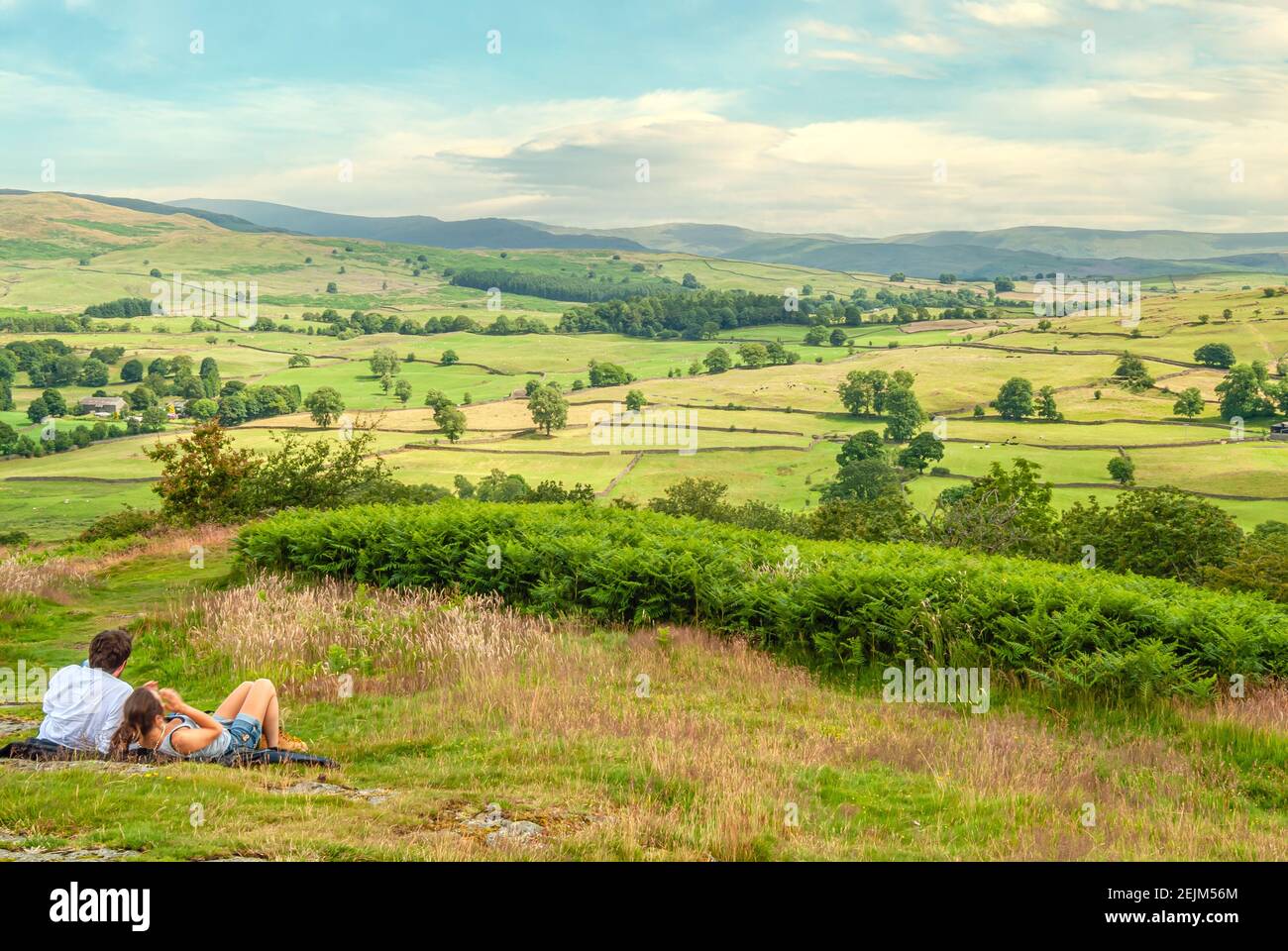 La giovane coppia gode della vista dal punto panoramico Orrest Head vicino a Windermere, Lake District, Cumbria, Inghilterra, Regno Unito Foto Stock