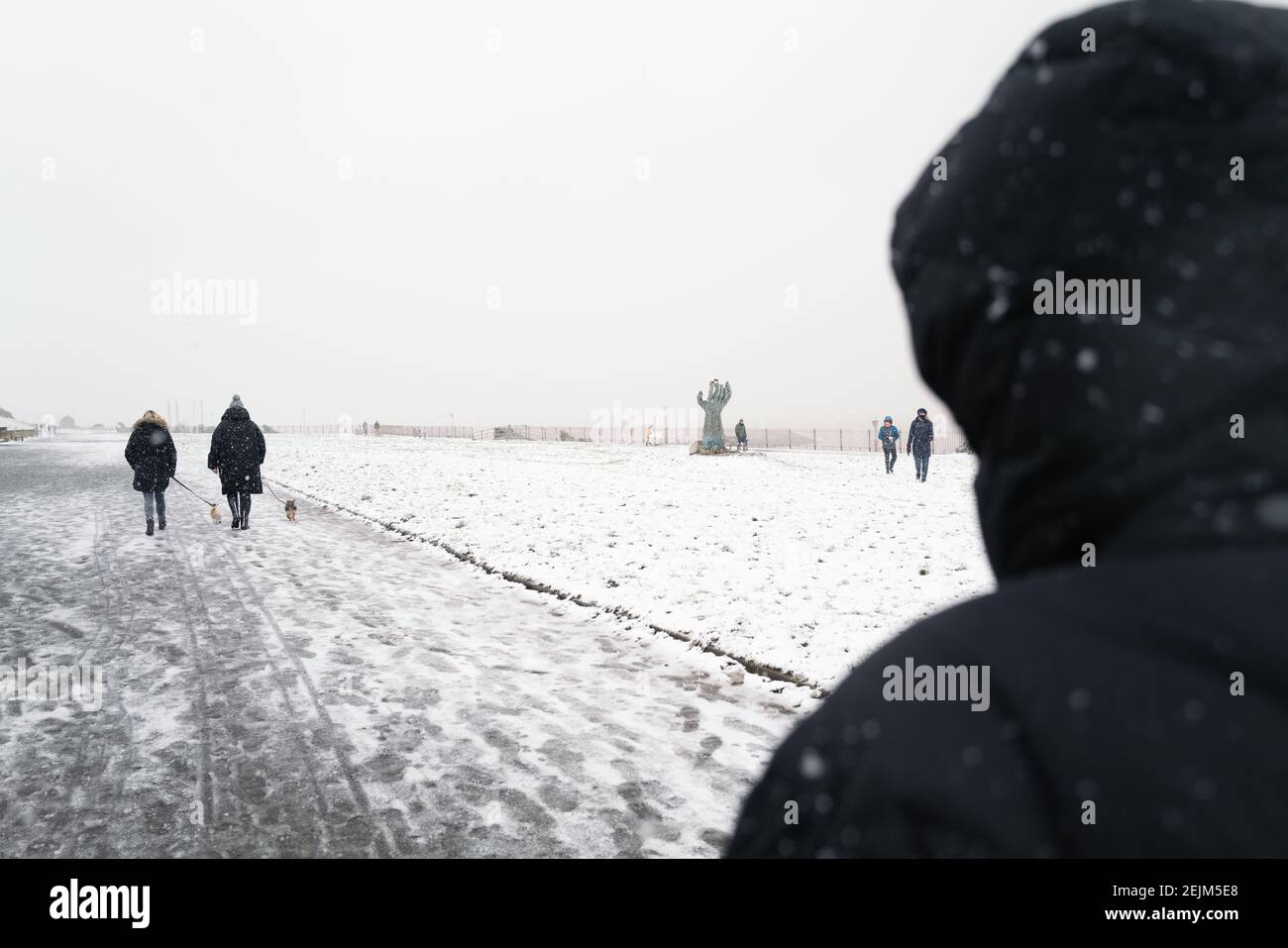 Ramsgate, Regno Unito - 7 febbraio 2021 persone a piedi i loro cani e bambini giocano sulla West Cliff Promenade nella neve portata dalla tempesta Darcy Foto Stock
