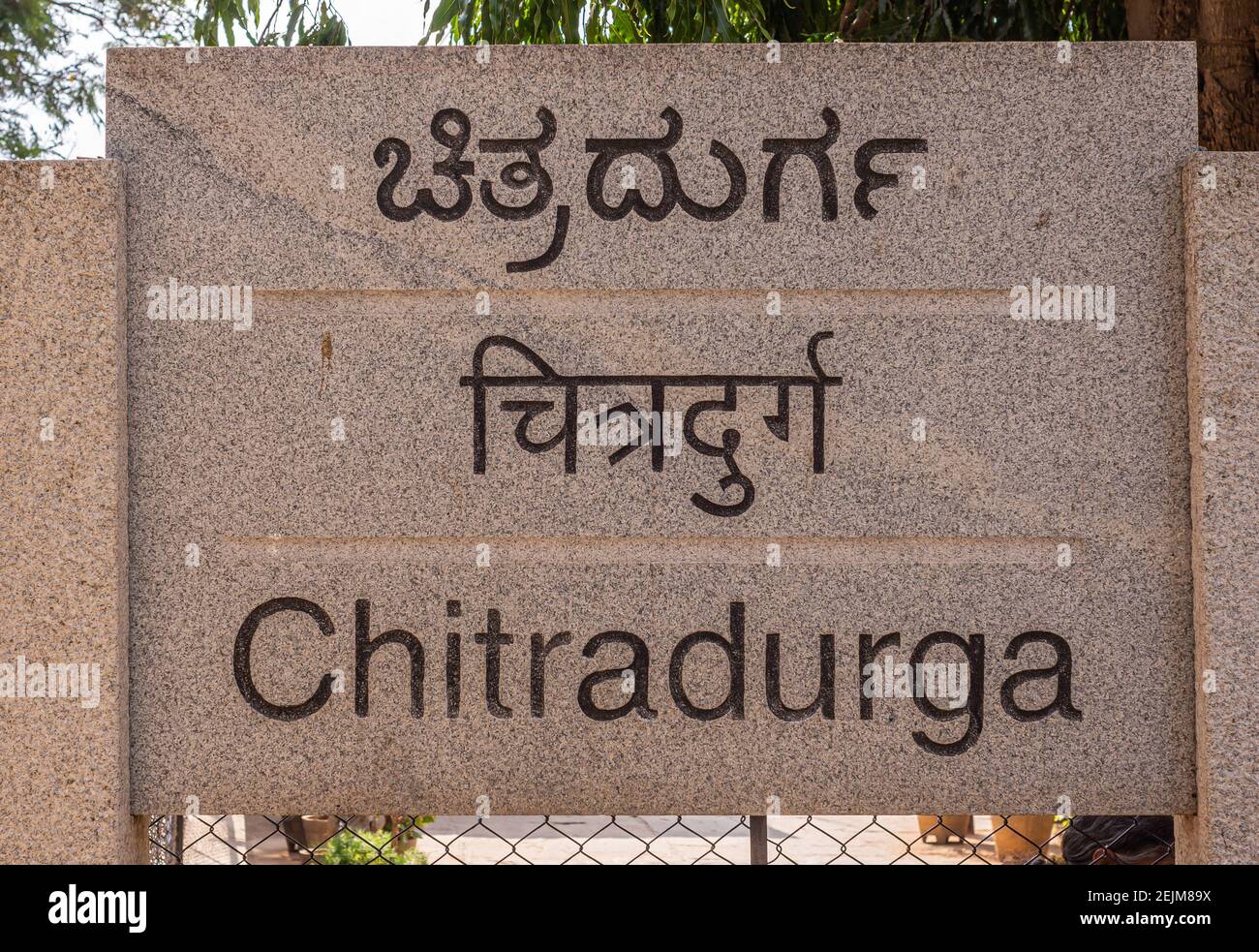 Chitradurga, Karnataka, India - 10 novembre 2013: Fort o Elusuttina Kote. Primo piano del cartello con il nome della città in lettere marrone scuro su pietra beige. 3 lan Foto Stock