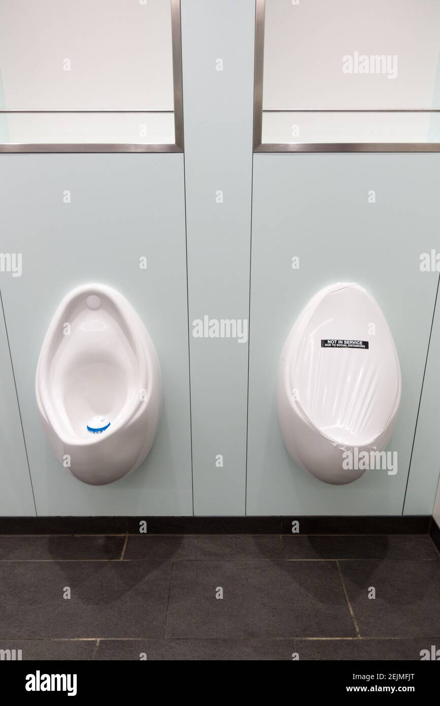 Divaricarsi sociale nella toilette di Mens Foto Stock