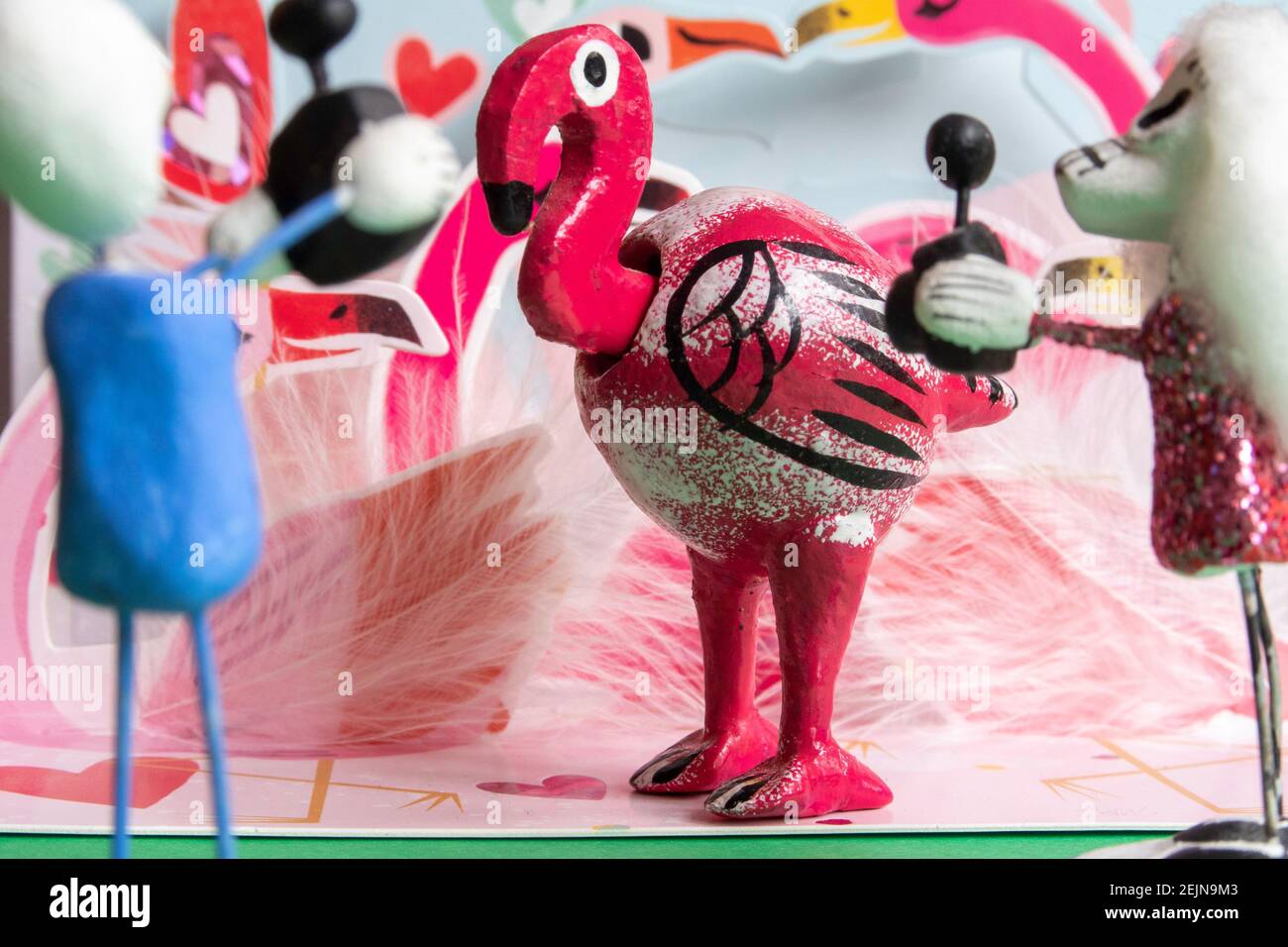 Giorno delle statuette del cranio di zucchero morto scattando una foto Di una mano scolpito testa di Bobble Flamingo Figura Foto Stock