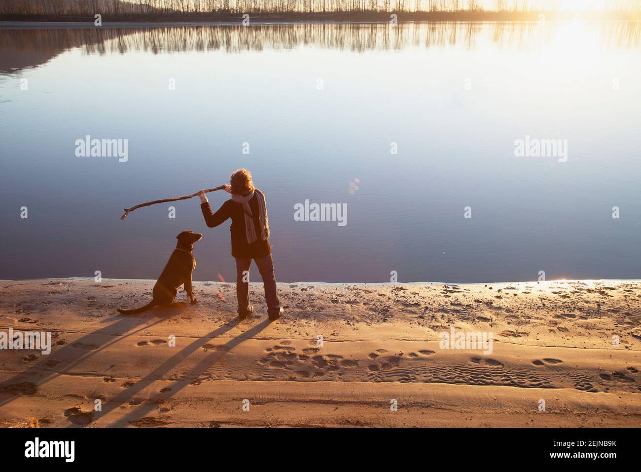 Donna e il suo cane che giocano sul fiume. Foto Stock