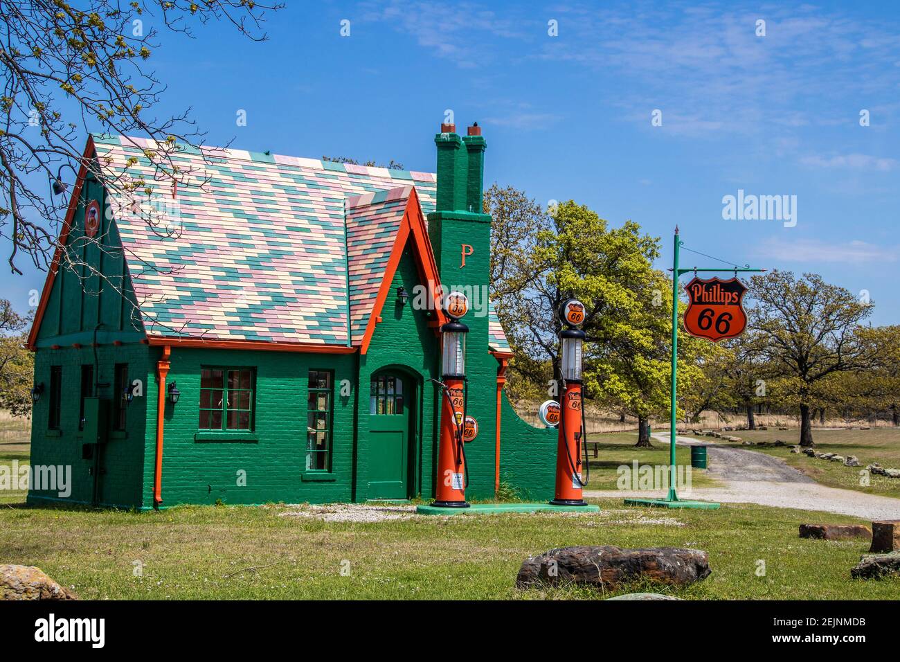 05-14-2020 Cushing OK USA - Colourful retro Phillips 66 gas Stazione circondata da alberi con vecchi segni di tempo e pompe Foto Stock