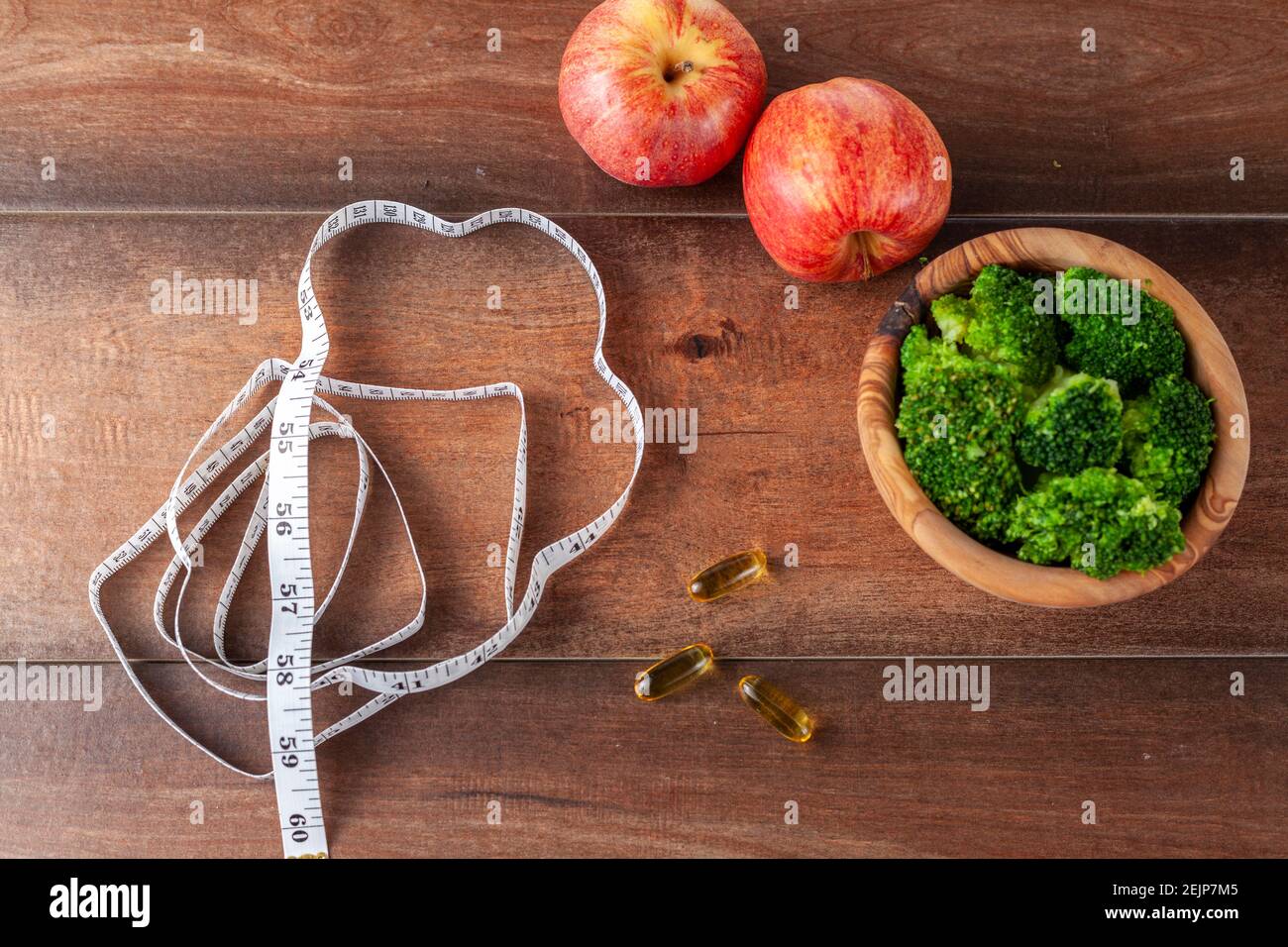 Una forma fisica, ottenere in forma, dieta, vita sana idea immagine con una vista ravvicinata in alto di un nastro di misurazione, integratori alimentari pillole, fresco broccoli Foto Stock