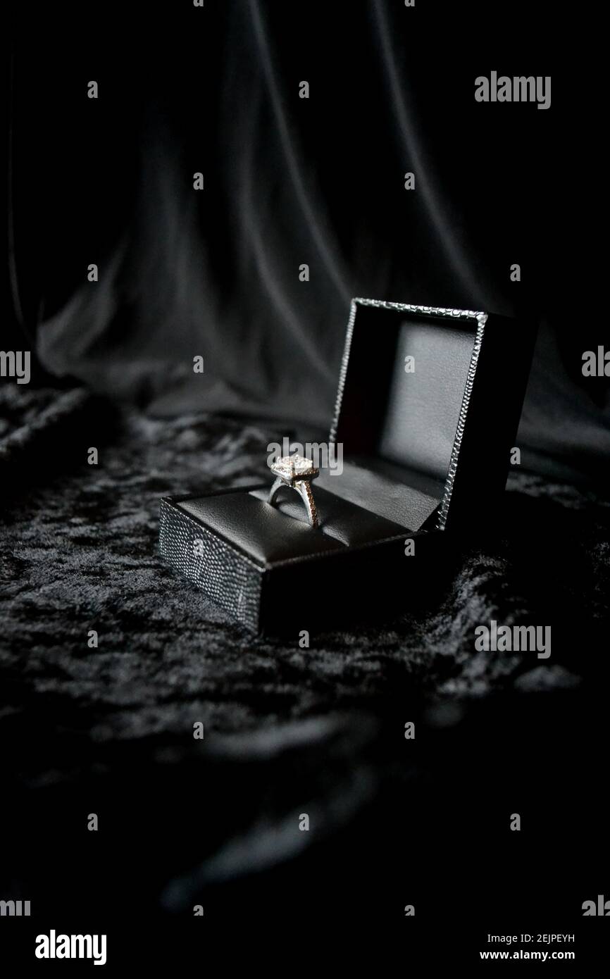anello in argento nella scatola ad anello su sfondo nero Foto Stock