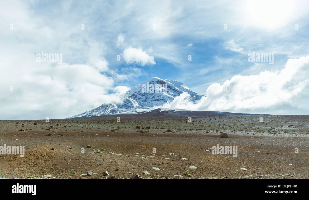 Colpo panoramico di vulcano Chimborazo innevato con cielo blu e nuvole. Viaggi di concetto in Ecuador, Sud America Foto Stock