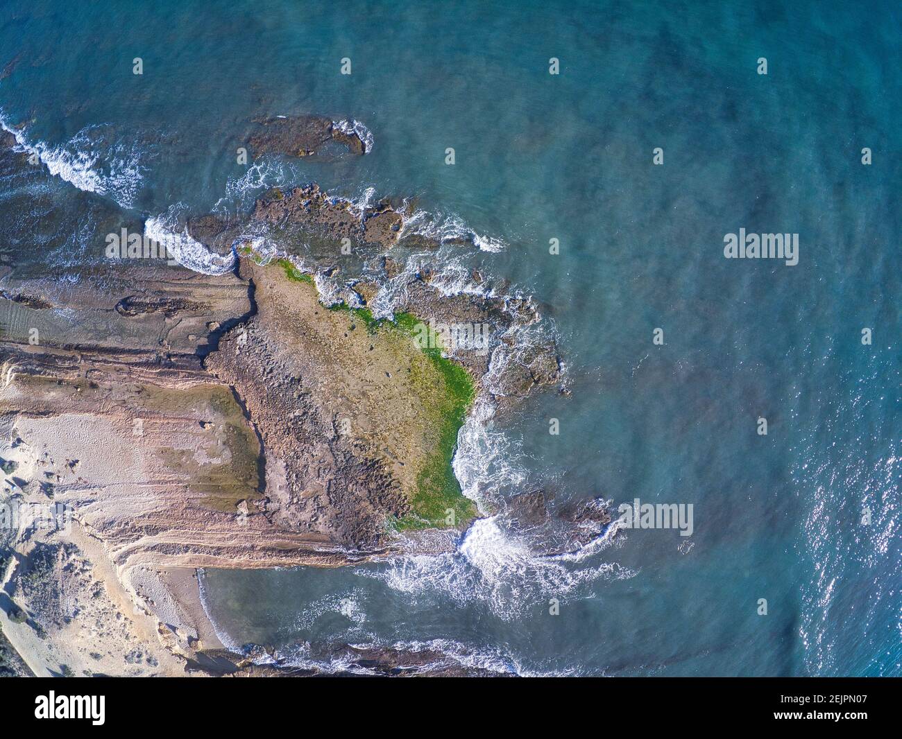 Veduta aerea del drone delle rocce della spiaggia di Cabo Huertas ad Alicante, situata nella Comunità Valenciana, Spagna. Mare e pietre Foto Stock