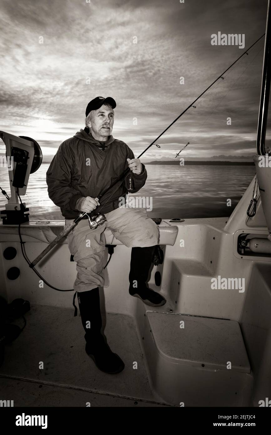 WA20087-00BW..... WASHINGTON - Phil Russell ci vuole un momento per rilassarsi mentre si pesca calamari sul Puget Sound. Foto Stock